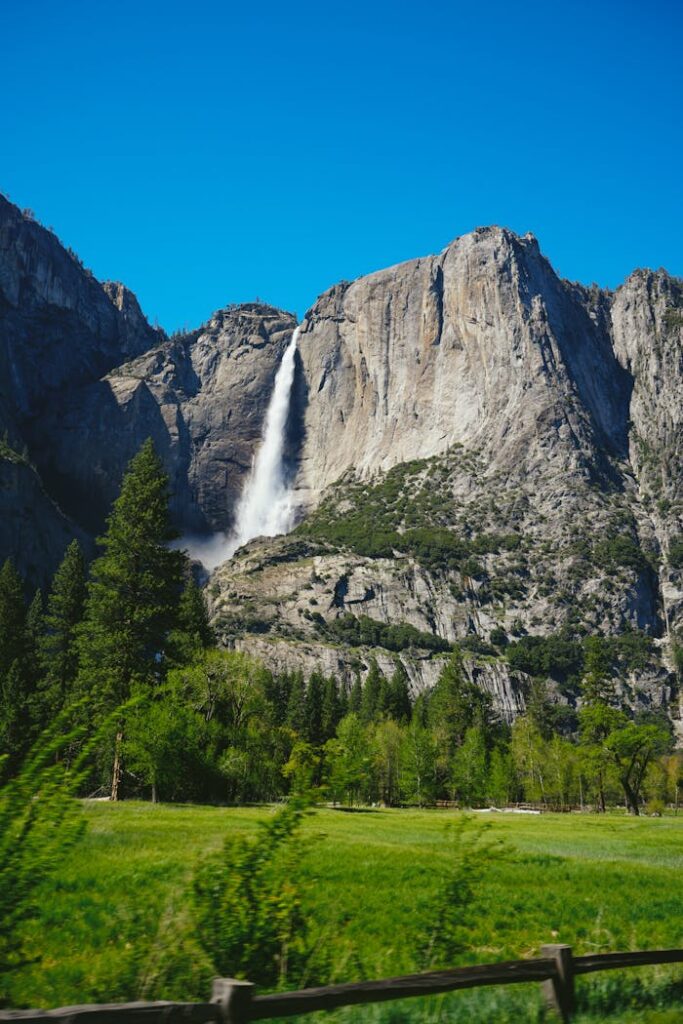 Beautiful view of a waterfall in Yosemite National Park under a clear blue sky.